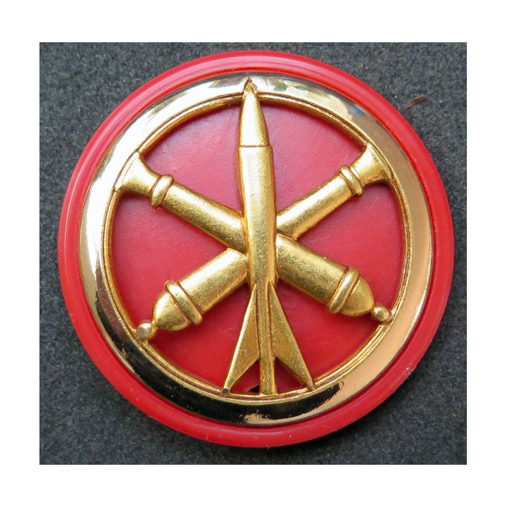 Insigne de béret de l'artillerie de fabrication Béraudy Vaure sur son support plastique rouge