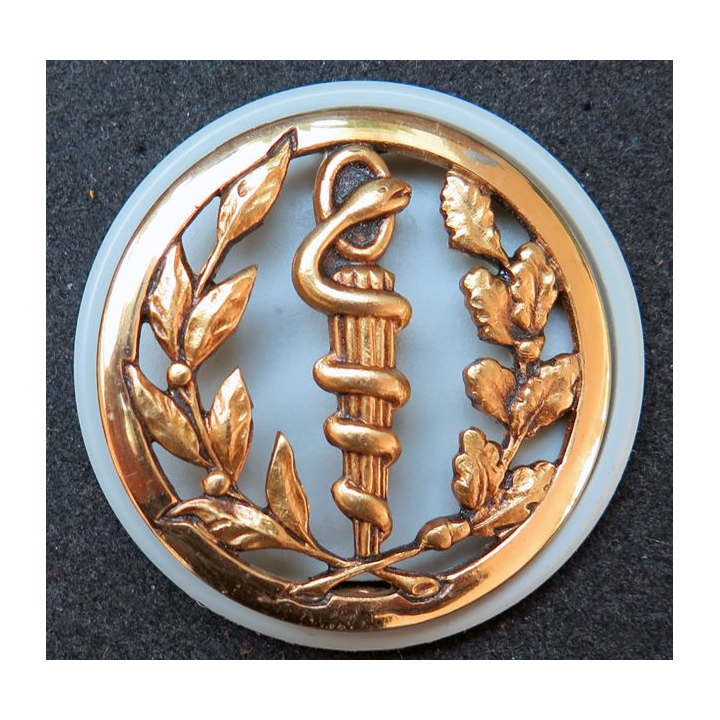 Insigne de béret du service de santé Coinderoux sur son support plastique gris perle