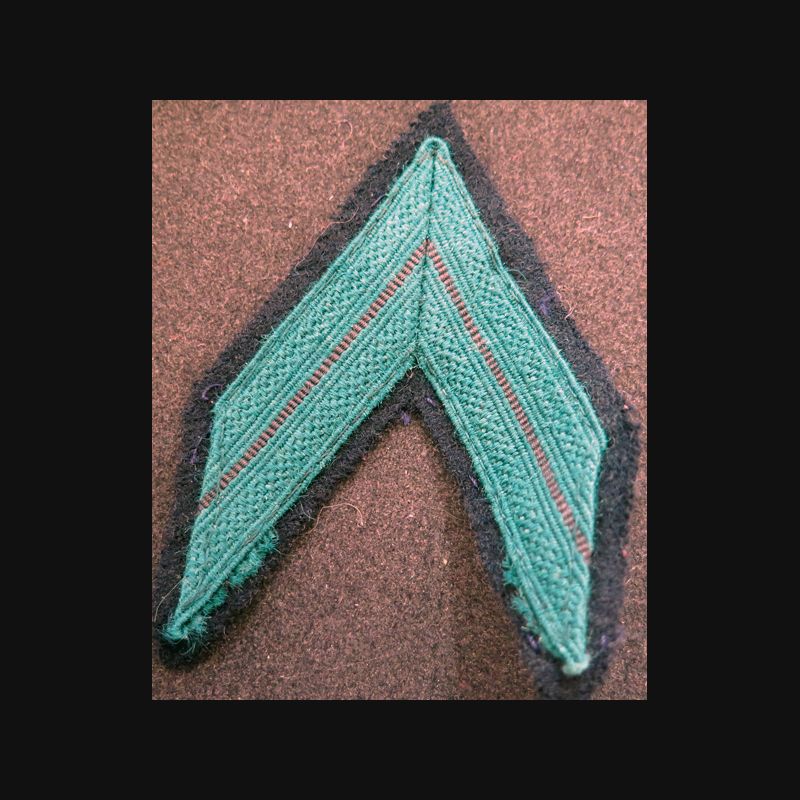 Galon de Caporal de la Légion vert sur tissu noir Galon de Caporal de la Légion vert sur tissu noir