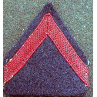 Galon de 1° Classe rouge sur tissu  bleu noir avec traces de colle