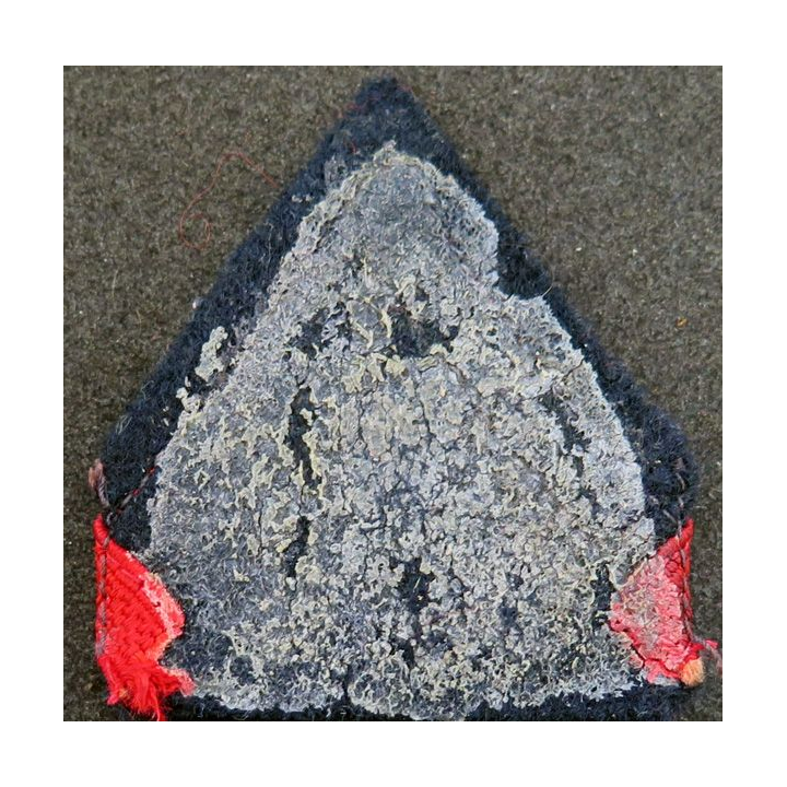 Galon de 1° Classe rouge sur tissu  bleu noir avec traces de colle