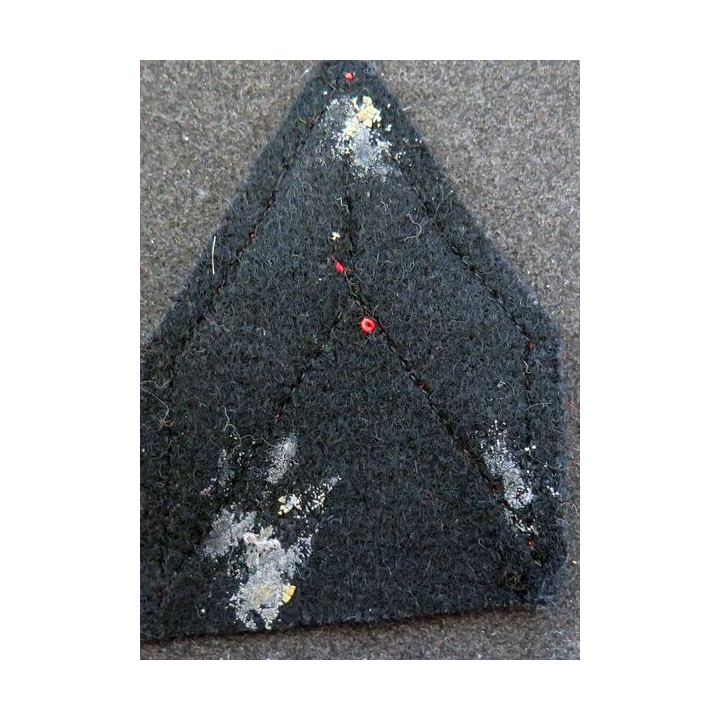 Galon de Caporal rouge sur tissu  bleu noir avec traces de colle