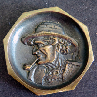 BRETAGNE : cendrier ou plaque en bronze d'un vieux breton fumant la pipe diamètre 8,7 cm