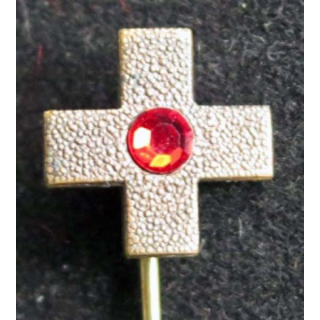 broche métallique croix avec une pierre rouge en son centre