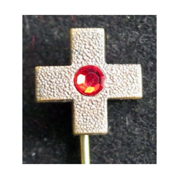 broche métallique croix avec une pierre rouge en son centre